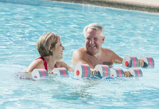 心脏和血管成熟的夫妇在游泳池做有氧运动
