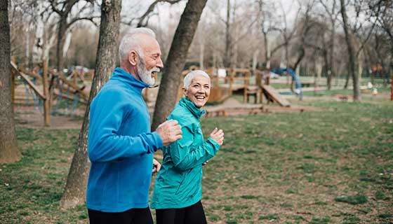 senior couple jogging in park